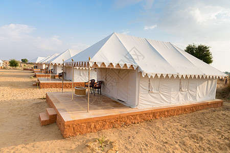 在沙漠中的帐篷露宿地旅馆晴天蓝色气候旅游植物旅行天空营地环境织物图片
