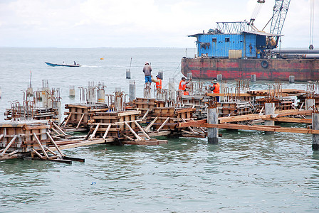 海中港口建设维修城市起重机造船加载建筑工作船运日落天际图片