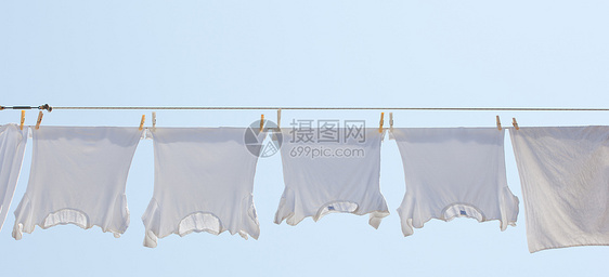 白色T恤衫挂在干燥处洗衣店天空蓝色别针裙子微风插图烘干衣夹衬衫图片