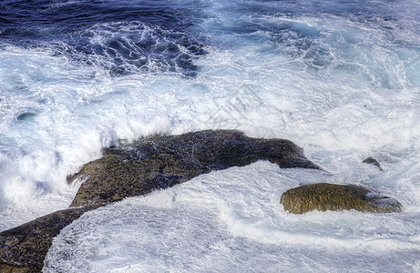 冲撞岩石的海洋海浪阳光旅行天气冲浪环境海滩天空蓝色碰撞海岸图片