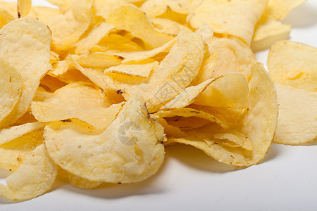 白背景孤立的土豆薯片色彩食物盐渍饼干波纹油炸宏观黄色小吃饮食图片