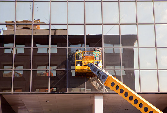 男子清洁窗户卫生公司天空团体建筑镜子起重机甲板房子中心图片