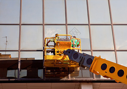 男子清洁窗户起重机男人中心职业摩天大楼建筑刷子公司清洁工城市图片