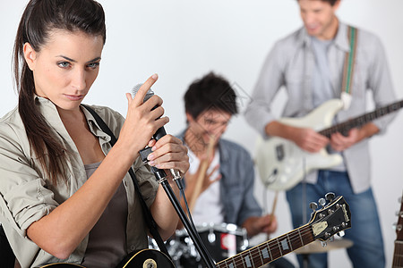 年轻摇滚乐队岩石音乐家会议麦克风唱歌男人吉他玩家演员音乐背景图片