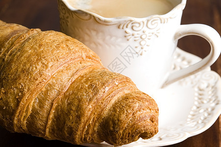 以黑咖啡和羊角面包为早餐杯子液体咖啡黑色报纸饮料食物图片