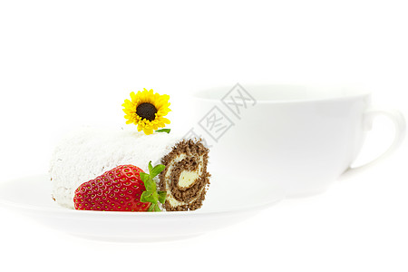 蛋糕卷 草莓和花朵放在盘子上图片