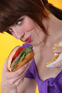 女人吃汉堡和薯条圆形筹码食物衬衫芝麻风俗女孩烹饪味觉面包图片
