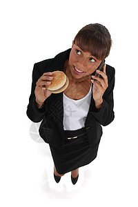 女商务人士 吃汉堡包 在她的牢房里说话图片