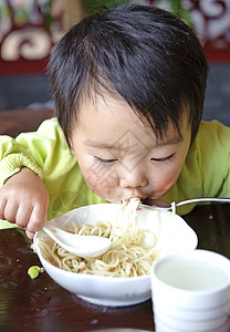 可爱的宝宝在吃东西面条后代肩膀托盘摄影孩子童年男生食物图片