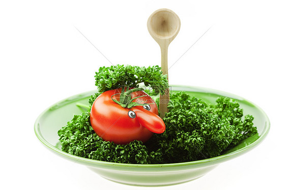 长着鼻子的西红柿 躺在绿色盘子上图片