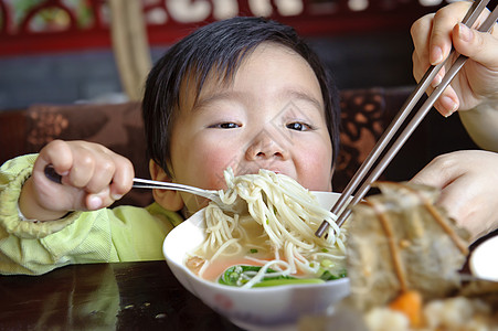 可爱的宝宝在吃东西后代托盘孩子童年摄影肩膀面条男生食物图片