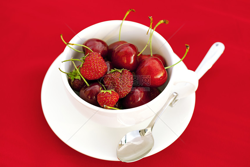 红背景的樱桃和草莓茶杯小路盘子浆果水果杯子食物勺子剪裁宏观餐具图片