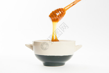 杯子和勺子里多汁的蜂蜜甜点美食静物蜜蜂营养液体木头金子产品流动图片