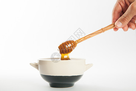杯子和勺子里多汁的蜂蜜甜点健康饮食金子营养流动玻璃液体蜜蜂静物美食图片