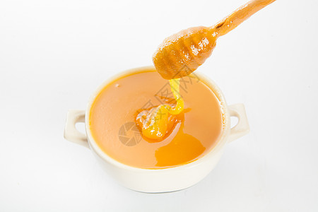 杯子和勺子里多汁的蜂蜜玻璃甜点金子蜜蜂美食产品流动木头健康饮食营养图片