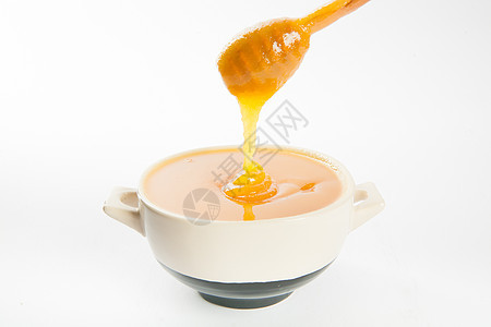 杯子和勺子里多汁的蜂蜜液体流动蜜蜂美食甜点玻璃木头营养金子健康饮食图片