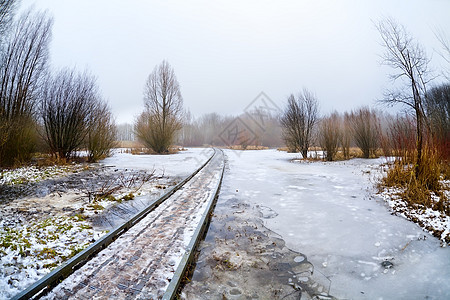 穿过冰冻湖的木制道路桥梁图片
