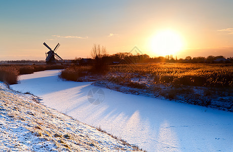 荷兰风车和冷冻运河的日出图片