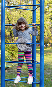 快乐的小女孩爬上公园操场图片