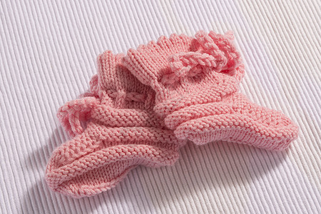 白色背景的粉红婴儿袜子图片