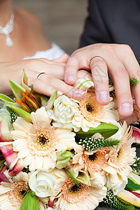 新娘和新郎的手躺在新娘花束上仪式百合快乐男人玫瑰珠宝女性誓言摄影结婚图片