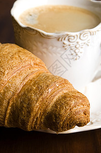 以黑咖啡和羊角面包为早餐饮料黑色液体食物报纸咖啡杯子图片