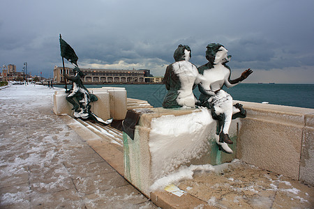 下雪的里雅斯特女裁缝旅游遗产青铜雕像雕塑季节银行旅行游客图片