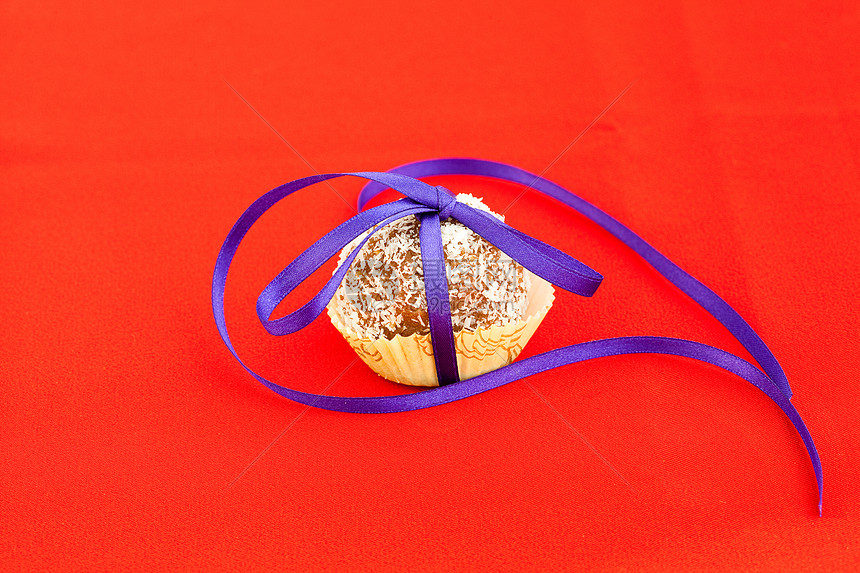 红色背景上绑着丝带的椰子蛋糕早餐蛋糕团体可可饼干橙子小吃收藏圆圈诱惑图片