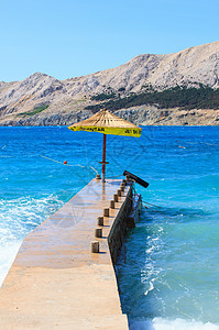 巴斯卡码头的保护伞沐浴者海水沿海旅行场景海岸波浪蓝色海滩旅游图片