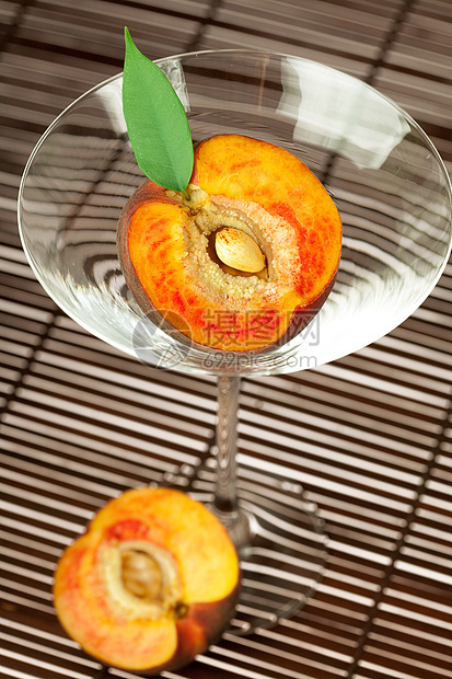 桃子和叶子 还有竹垫上的马提尼酒杯玻璃木头棕色黄色水果食物条纹材料圆圈红色图片
