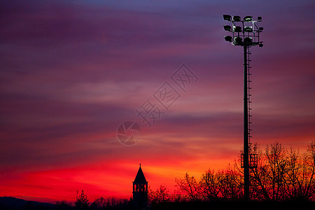 日落 钟楼红色尖顶剪影教会时间天空体育场气氛路灯图片