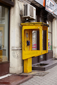 黄色公共电话讲话民众拨号数字货币绳索电讯城市技术街道图片