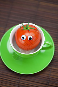 竹垫上杯子里有眼睛的西红柿笑脸创造力飞溅奶奶食物飞碟陶瓷木头早餐菜肴图片