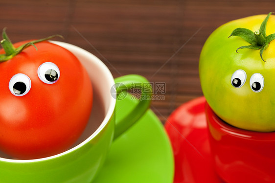 竹垫上杯子里有眼睛的西红柿木头飞溅创造力蔬菜菜肴用具食物飞碟陶瓷早餐图片
