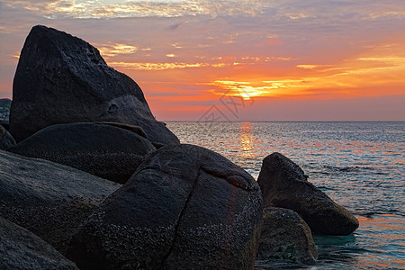 海洋海岸的巨石 在热带日落前图片