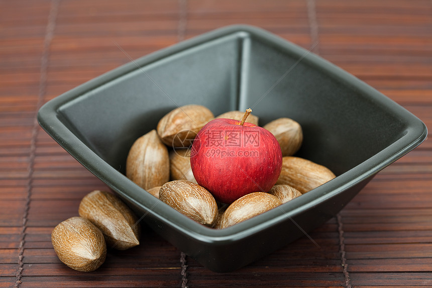 竹垫上一个碗里的小豆和苹果力量水果坚果摄影食物工作室美食圆圈小吃木头图片