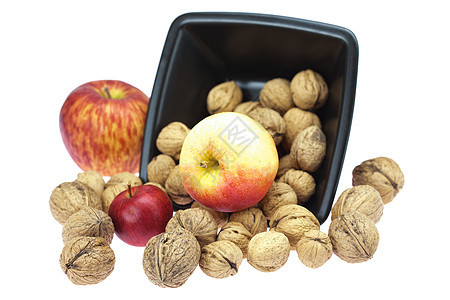 碗中的胡桃子和白墨的苹果种子宏观木头食物力量餐具圆圈水果坚果小吃图片