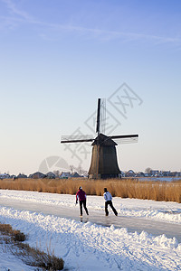 冬季风车 有雪 冰和蓝天空历史性溜冰者房子风景滑冰建筑学农村刀刃天空地标图片