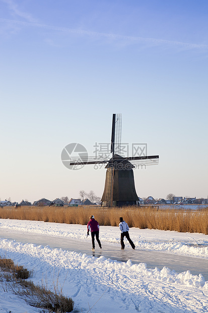 冬季风车 有雪 冰和蓝天空历史性溜冰者房子风景滑冰建筑学农村刀刃天空地标图片