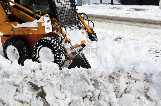 清扫街道上积雪的黄色拖拉机推土机行动司机挖掘机车轮卡车机械打扫刀刃装载机图片