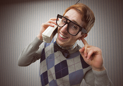 使用旧移动电话的呆子学生毛衣风格复古壁纸手机领结极客年轻人快乐红发图片