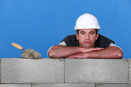 铁砖匠 头戴粗胸的木砖人休息在臂膀上图片