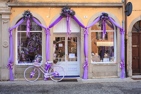 紫色自行车旁边的熏衣草店装饰展示蝴蝶结把手运输薰衣草轮子植物丝带图片