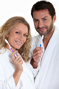 带牙刷的男人和女人金发女郎卫生白色长袍浴室女士日常生活头发图片