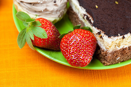 橙色织物上躺着的草莓和蛋糕奢华叶子盘子橙子食物浆果柠檬甜点糕点巧克力图片