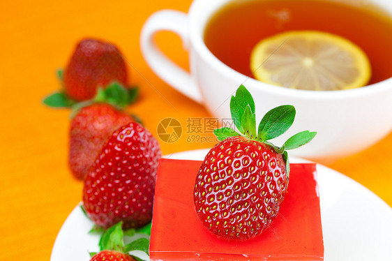 柠檬茶 蛋糕和草莓 放在橙色织物上文化巧克力早餐橙子液体坚果浆果柠檬糕点糖果图片