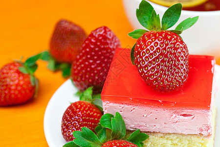 柠檬茶 蛋糕和草莓 放在橙色织物上叶子糕点水果奢华甜点文化盘子食物飞碟液体图片