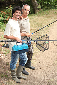 父亲和儿子去钓鱼旅行涉水运动渔民岩石海滩男人卷轴靴子垂钓者男性图片