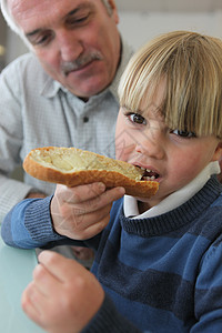 男孩和爷爷一起吃面包图片