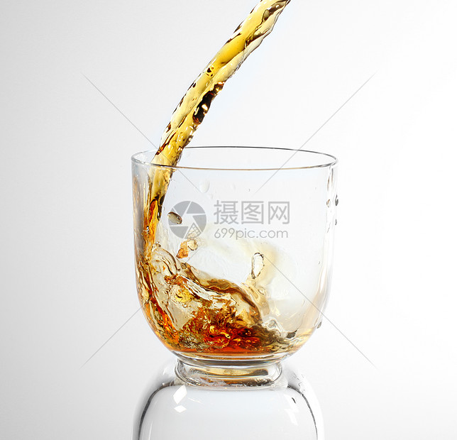 威士忌倒在玻璃杯里飞溅液体流动玻璃图片